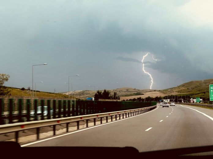 Burza z piorunami nad autostradą widzianą z jadącego samochodu