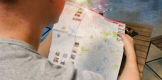 Podróżnik pochylony nad mapą, planuje trasę swojej wycieczki