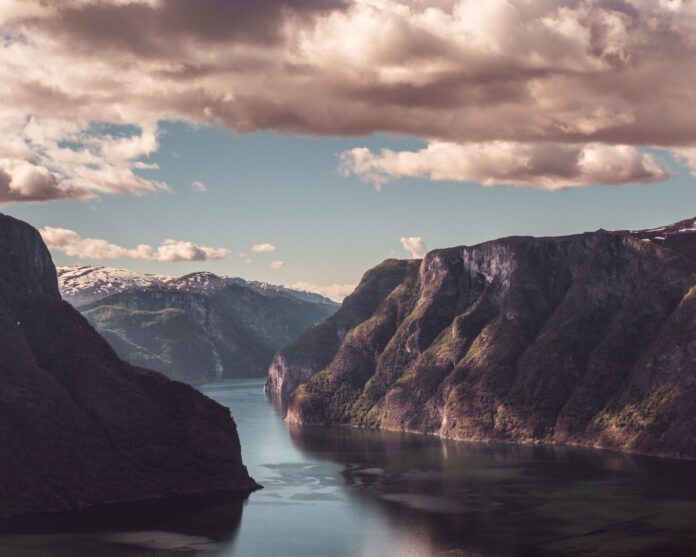 Fiord Aurlandsfjord o zachodzie słońca, góry i spokojne niebo w Norwegii