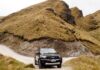 SUV na szutrowej drodze w górskim krajobrazie Coronet Peak w Nowej Zelandii