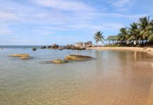 Tropikalna plaża w Wietnamie z palmami, skałami i krystaliczną wodą