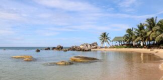 Tropikalna plaża w Wietnamie z palmami, skałami i krystaliczną wodą